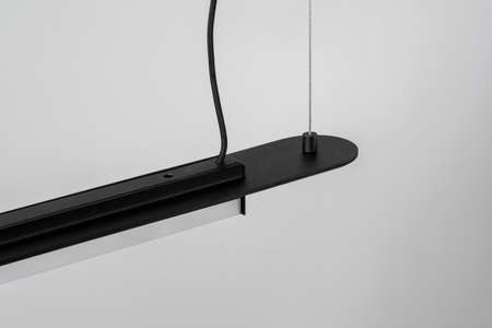 Black metal lamp hanging on gray wall background in studioの写真素材