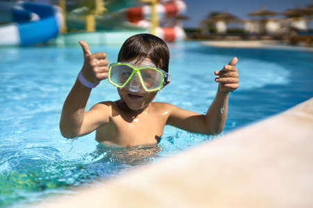 Small boy posing in green swim mask in aquaparkの写真素材