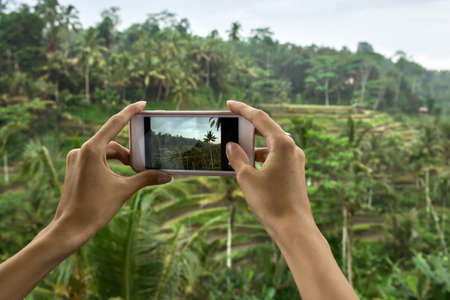 Woman shooting photo on terraced rice fields background on Baliの写真素材