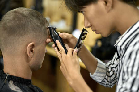 Man is cutting his hair in asian barbershopの写真素材