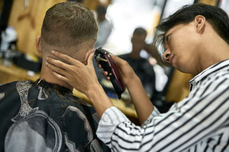 Man is cutting his hair in asian barbershopの写真素材