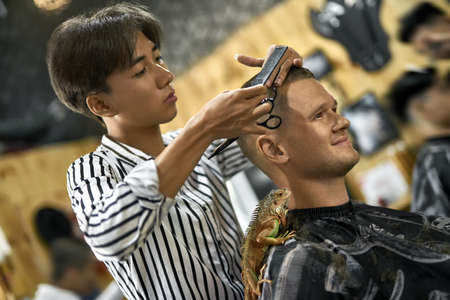 Man is cutting his hair in asian barbershopの写真素材