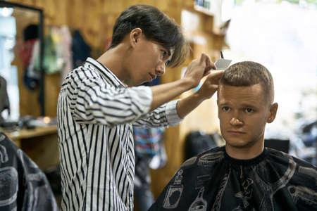 Man is cutting his hair in asian barbershopの写真素材