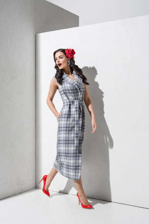 Brunette model in stylish coat and accessories posing in studioの写真素材