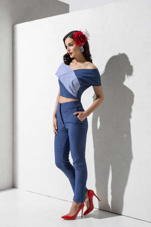 Brunette model in colorful clothing and accessories posing in studioの写真素材