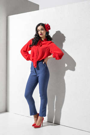 Brunette model in colorful clothing and accessories posing in studioの写真素材