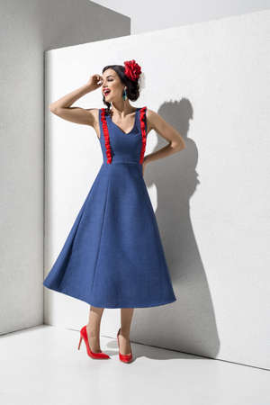 Brunette model in colorful dress and accessories posing in studioの写真素材