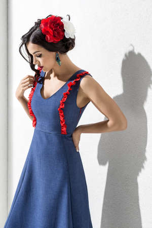 Brunette model in colorful dress and accessories posing in studioの写真素材