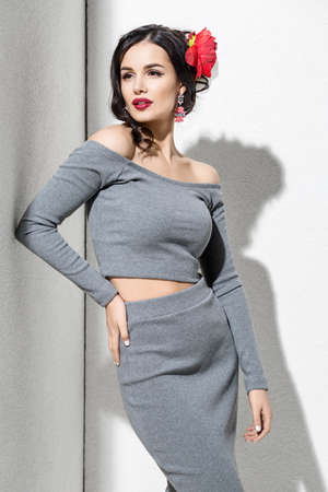 Brunette model in stylish clothing and accessories posing in studioの写真素材