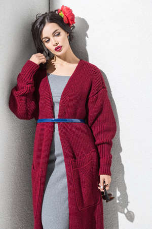 Brunette model in colorful clothing and accessories posing in studioの写真素材