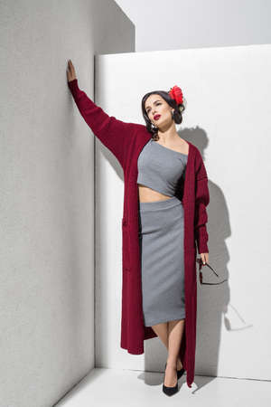 Brunette model in colorful clothing and accessories posing in studioの写真素材