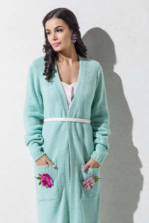 Brunette model in colorful clothing and accessories posing in studioの写真素材