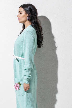 Brunette model in colorful clothing and accessories posing in studioの写真素材