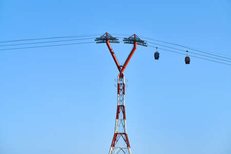 Red-white ropeway with two moving colorful cabinsの写真素材