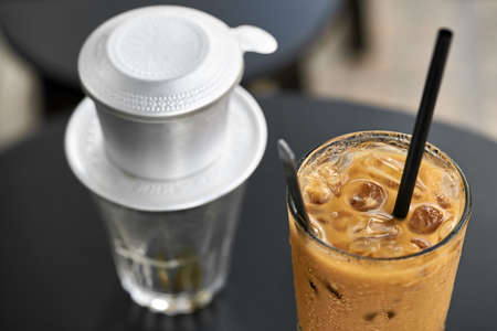 Macro photo of iced coffee drink on black table outdoors