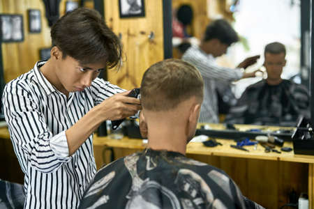 Man is cutting his hair in asian barbershopの写真素材
