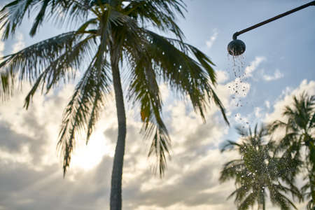 Beach shower with flowing water on old metal pipe