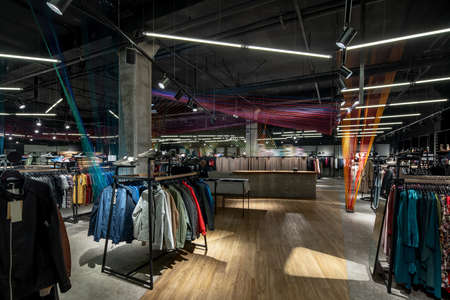 Modern clothes shop with large selection of different wear and shoesの写真素材
