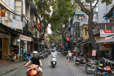 Picturesque asian street with many parked motorbikesのeditorial素材