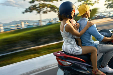 Parents with their child riding motorcycle on sunny city streetの写真素材