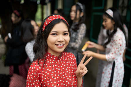Outdoor portrait of pretty asian girl in red clothes