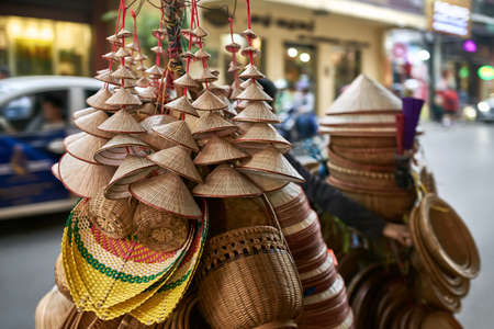 Street seller with asian conical wooden hats and basketsの写真素材
