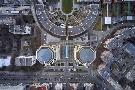 Modern district with two skylines with flags on their tops in city of Dnipro in Ukraine. There are many parked cars. Top view horizontal photo.の写真素材