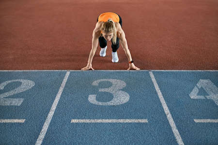 Athletic blonde woman training at indoor stadiumの写真素材