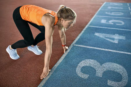 Athletic blonde woman training at indoor stadiumの写真素材