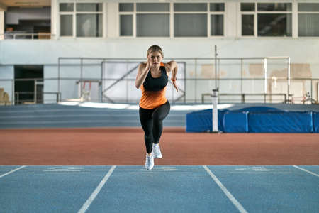 Athletic blonde woman training at indoor stadiumの写真素材