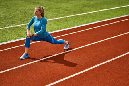 Sportive blonde woman training at open stadiumの写真素材