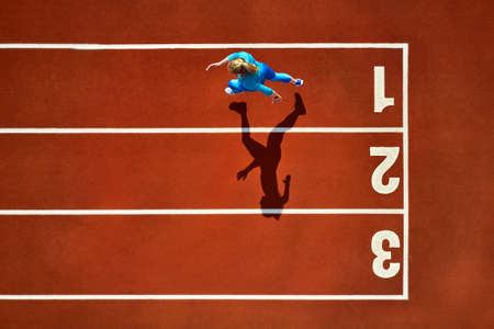 Sportive blonde woman running at open stadiumの写真素材
