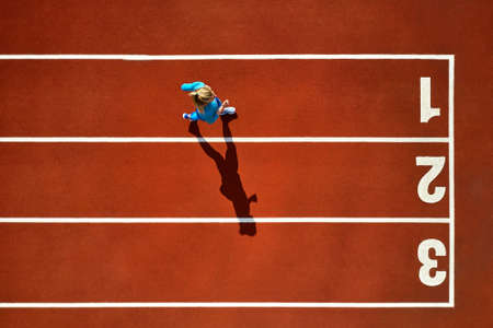 Sportive blonde woman running at open stadiumの写真素材