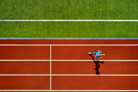 Sportive blonde woman running at open stadiumの写真素材