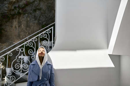 Beautiful woman posing on sunny old town streetの写真素材