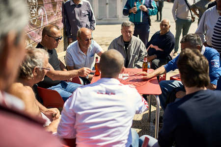 Italian men playing cards on sunny street