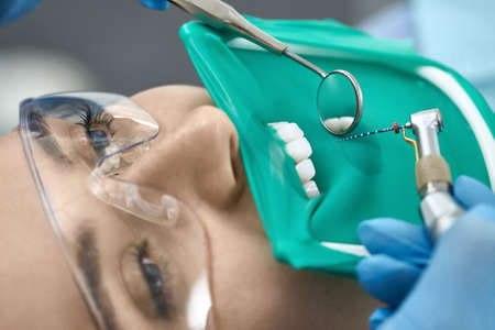 Pretty womans teeth treatment in dental clinicの写真素材