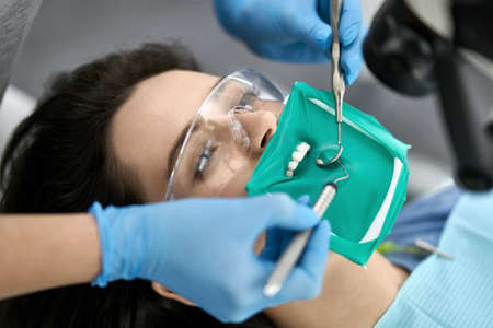 Pretty womans teeth treatment in dental clinicの写真素材
