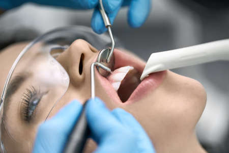 Pretty womans teeth cleaning in dental clinicの写真素材