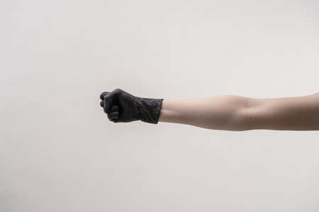 Hands in black silicone gloves on a light background.の写真素材