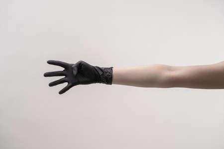 Hands in black silicone gloves on a light background.の写真素材