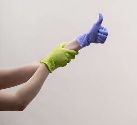 Aesthetic female hands in multi-colored silicone gloves.