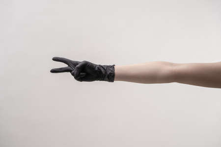 Hands in black silicone gloves on a light background.の写真素材