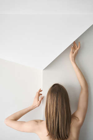 Woman posing from the back in light interiorの写真素材
