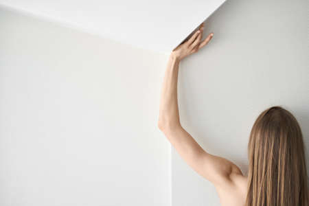 Woman posing from the back in light interiorの写真素材