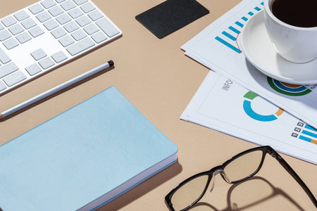 Work desk with papers, notepad, phone and coffeeの写真素材