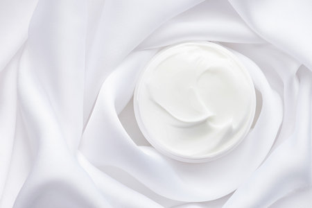 Tube with cream on white silk. Mockupの写真素材