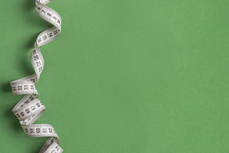 White measuring tape on a green background