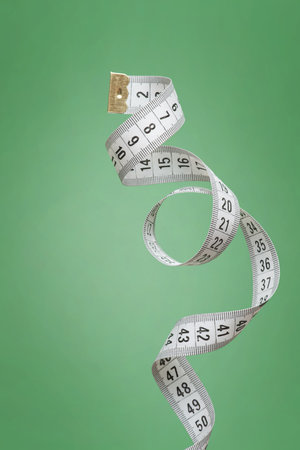 White measuring tape on a green background