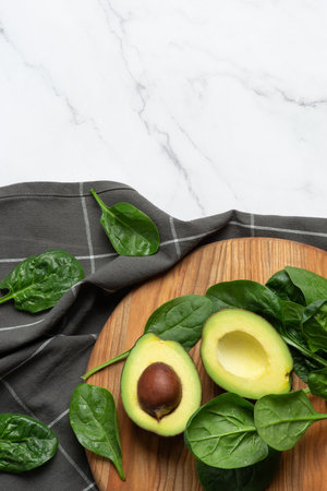 Gray culinary background with ingredients for green salad. Spinach with avocado and grapes.